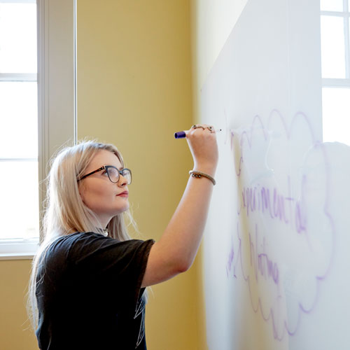 Student writing on a white board