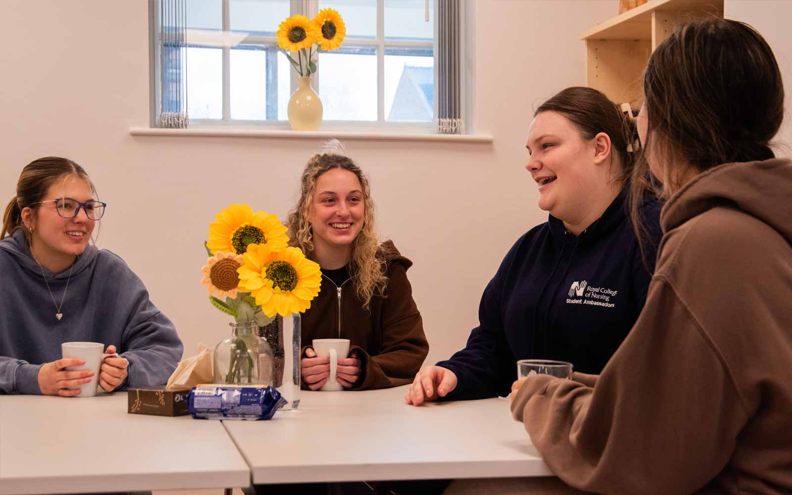 Four people talk together in a Communities Centre session.