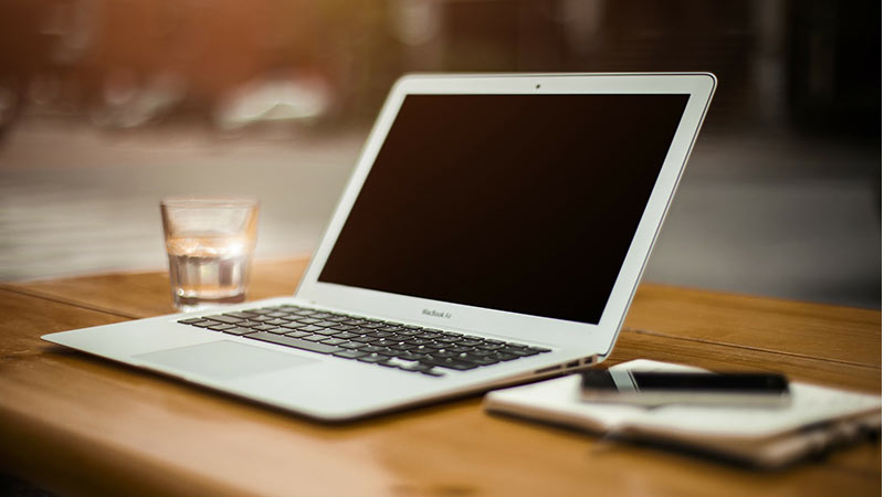 Laptop and notepad on table