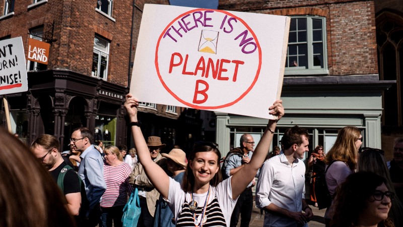A smiling student holding a placard