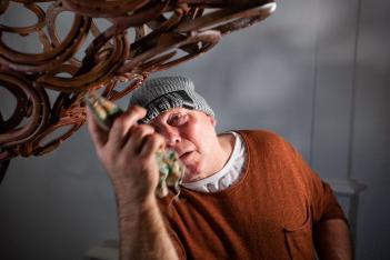 A male artist at work on a metal sculpture