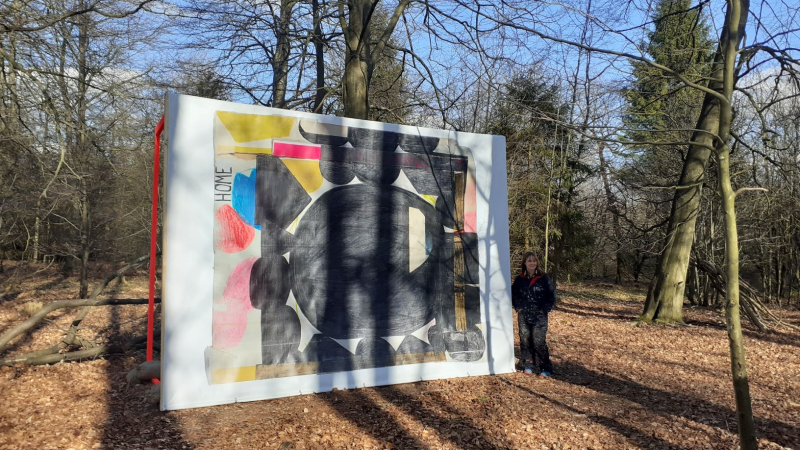 A large scale abstract artwork displayed in a forest setting