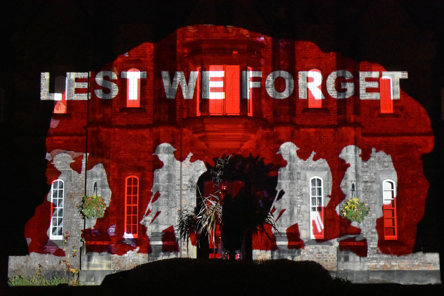 Poppy themed light projection onto Lord Mayor's Walk campus building