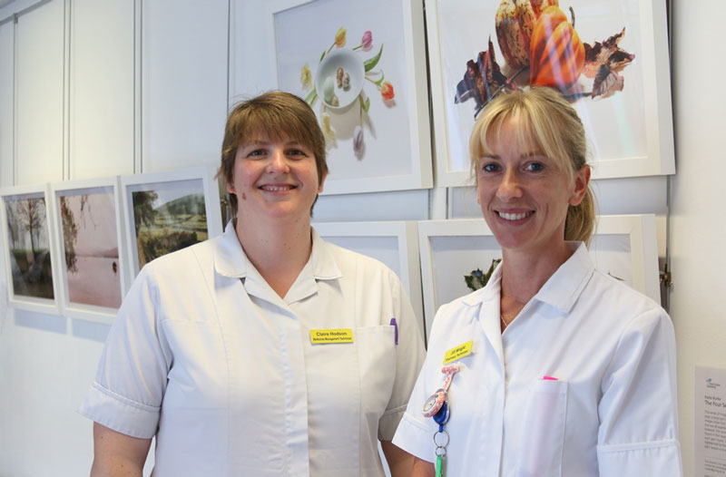 NHS Technicians in front of students' photography exhibition