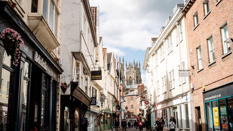 A street of shops with York Minster in the background