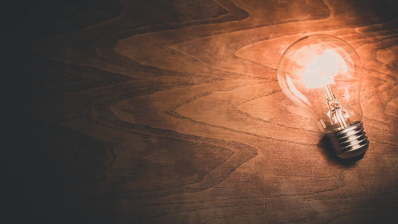 A lightbulb on a wooden desk