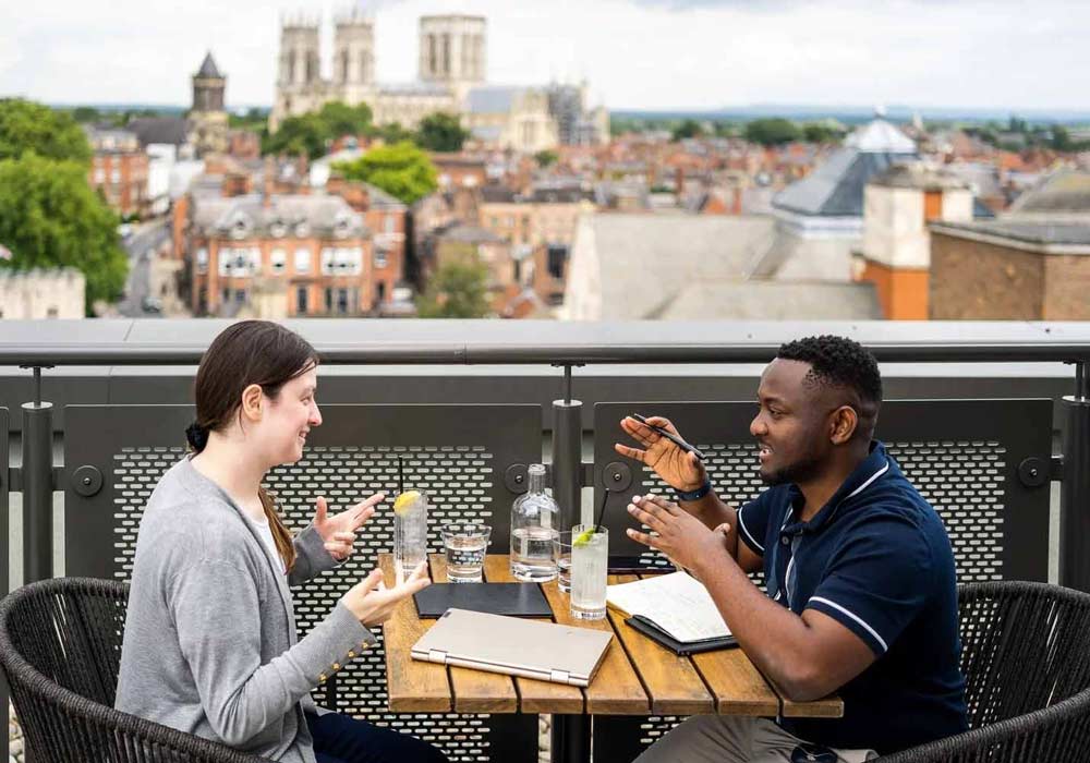 Students socialising at Sora Bar with a view of York Minster