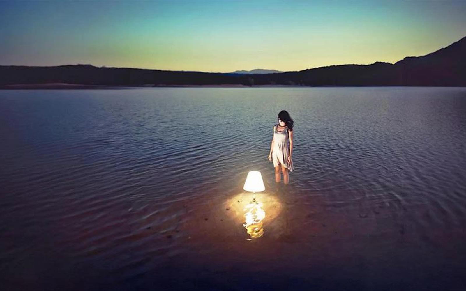 An image of a woman and a lamp in a lake, created by Ibai Acevedo.