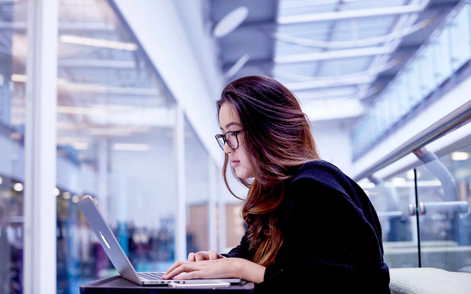A student studying at her laptop on the Second Floor of Fountains