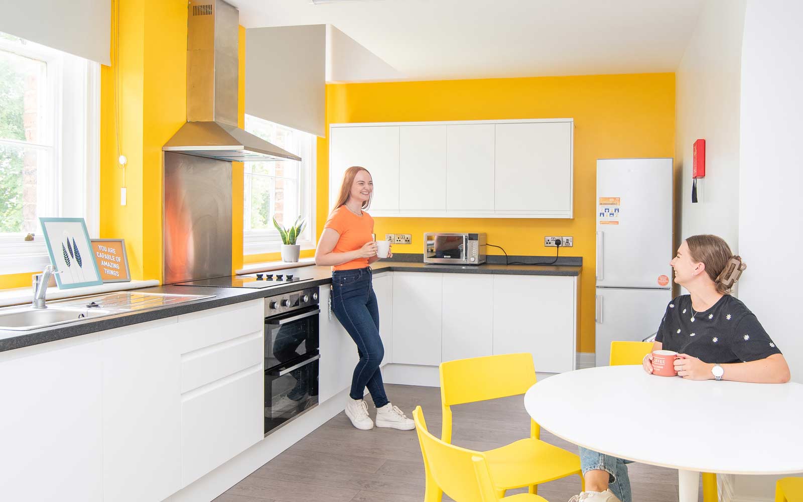 Two students in a student accommodation kitchen.