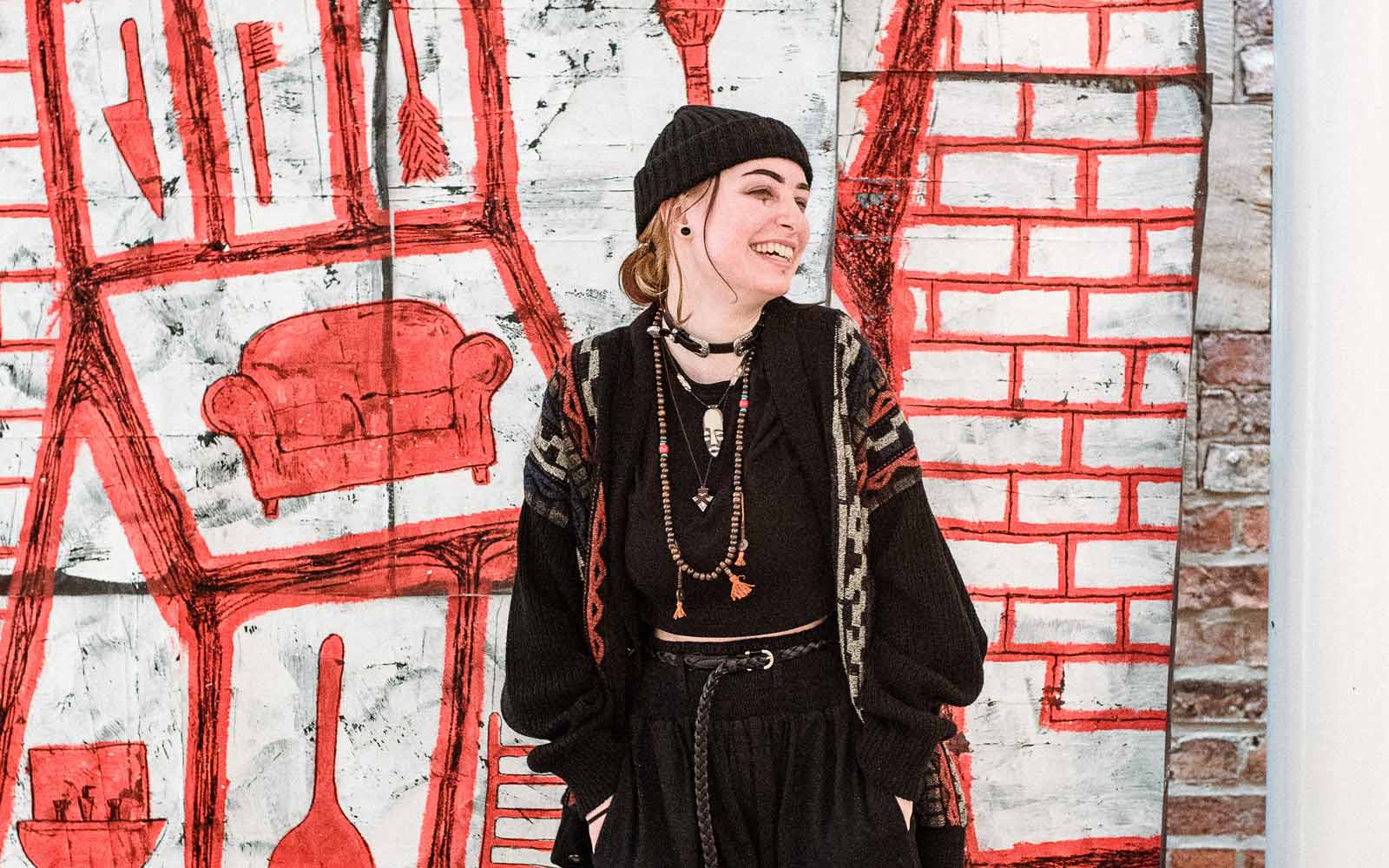A student in front of an art mural.