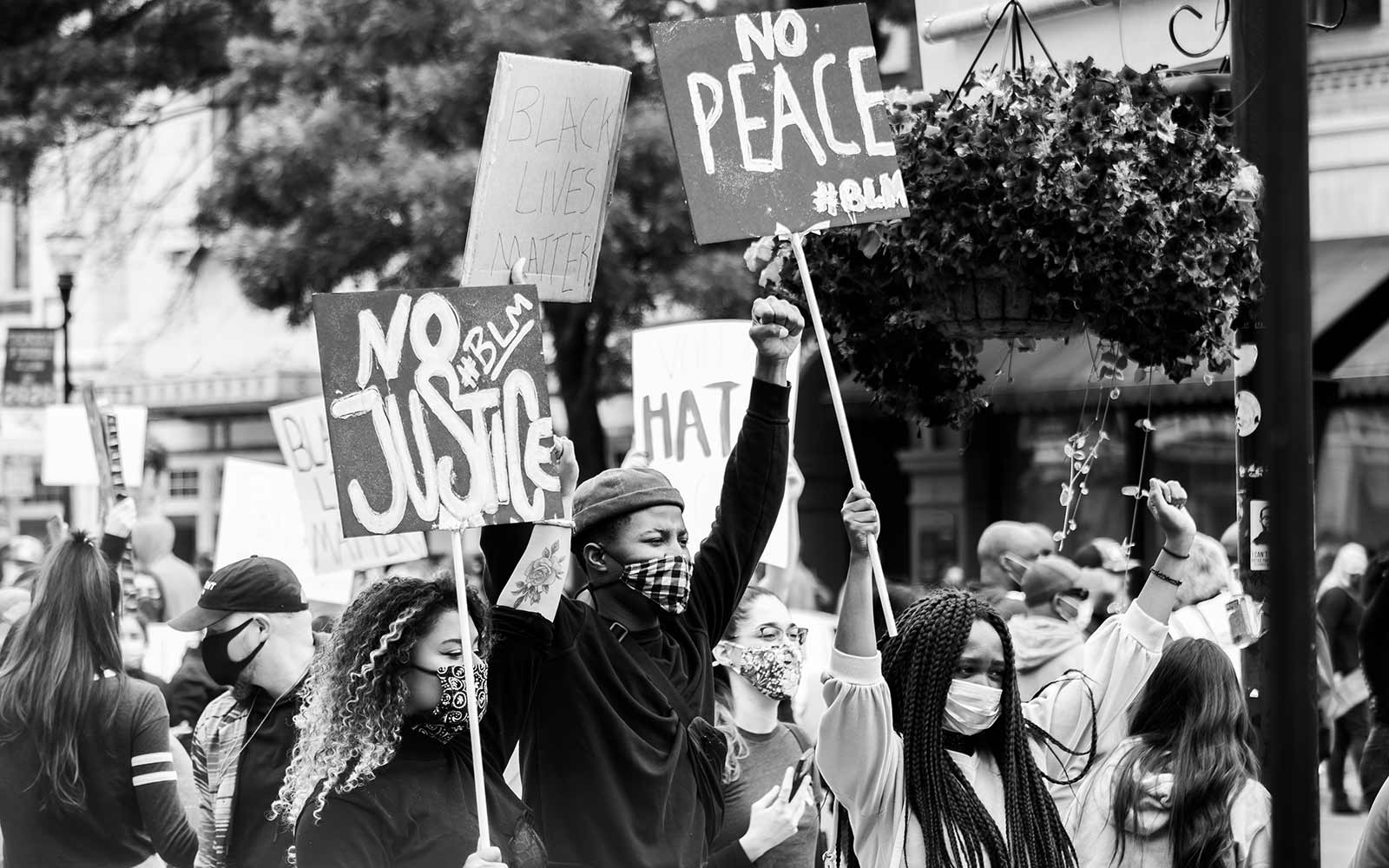 Black and white image of protesters holding signs and walking down street during Black Lives Matter protest