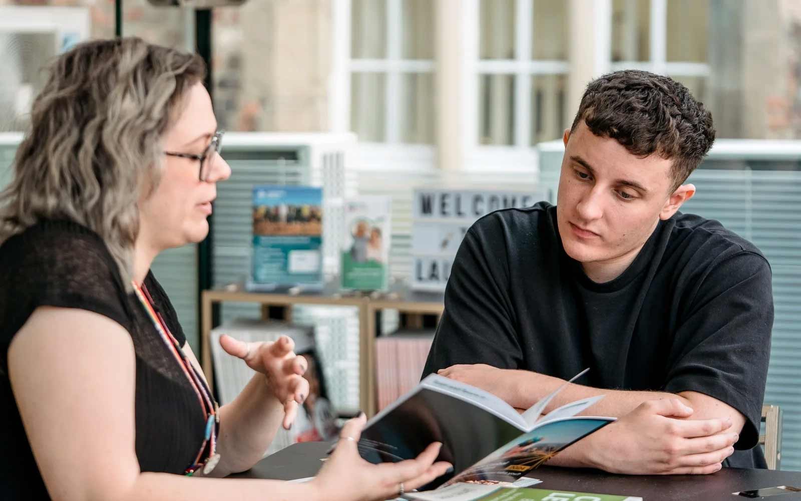 A staff and student discussing careers and funding.