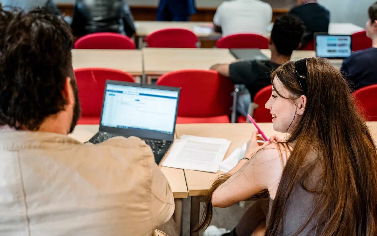 Students in lecture theatre working on a laptop