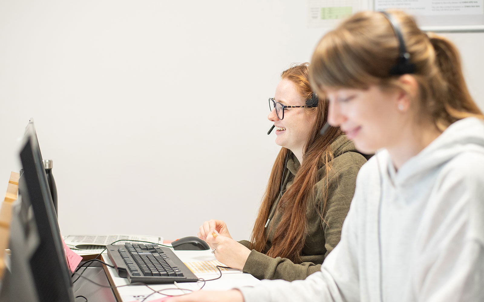Two staff members using headsets to take Clearing calls