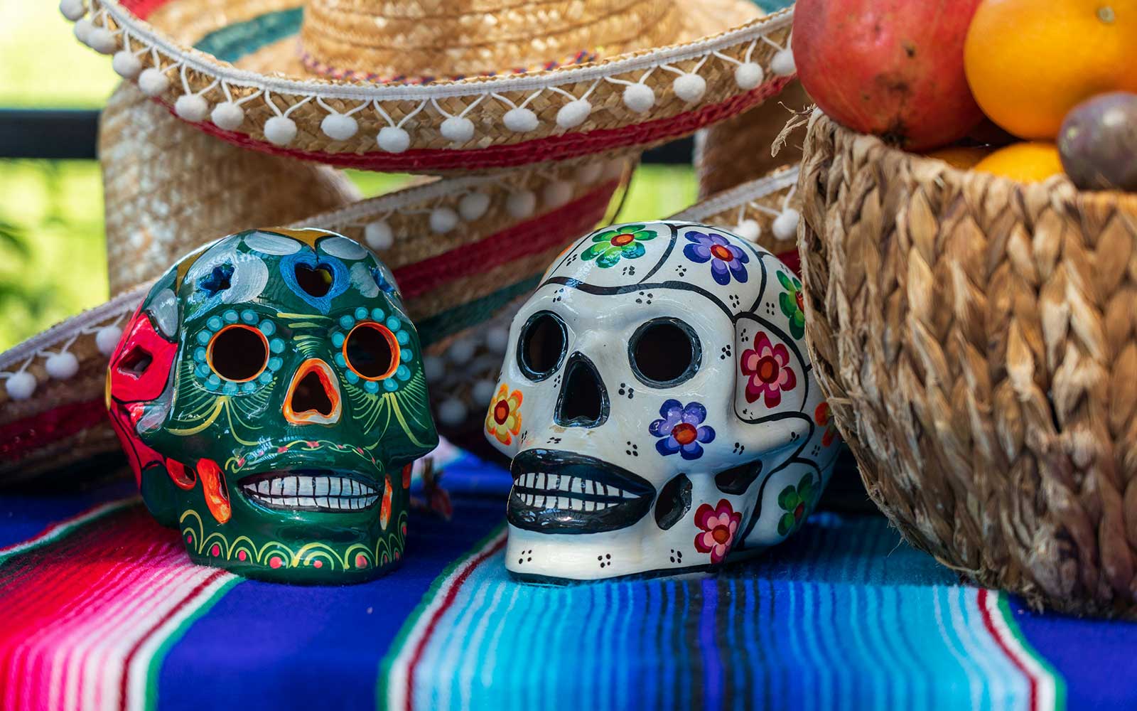 Day of the Dead skulls on table with basket of food
