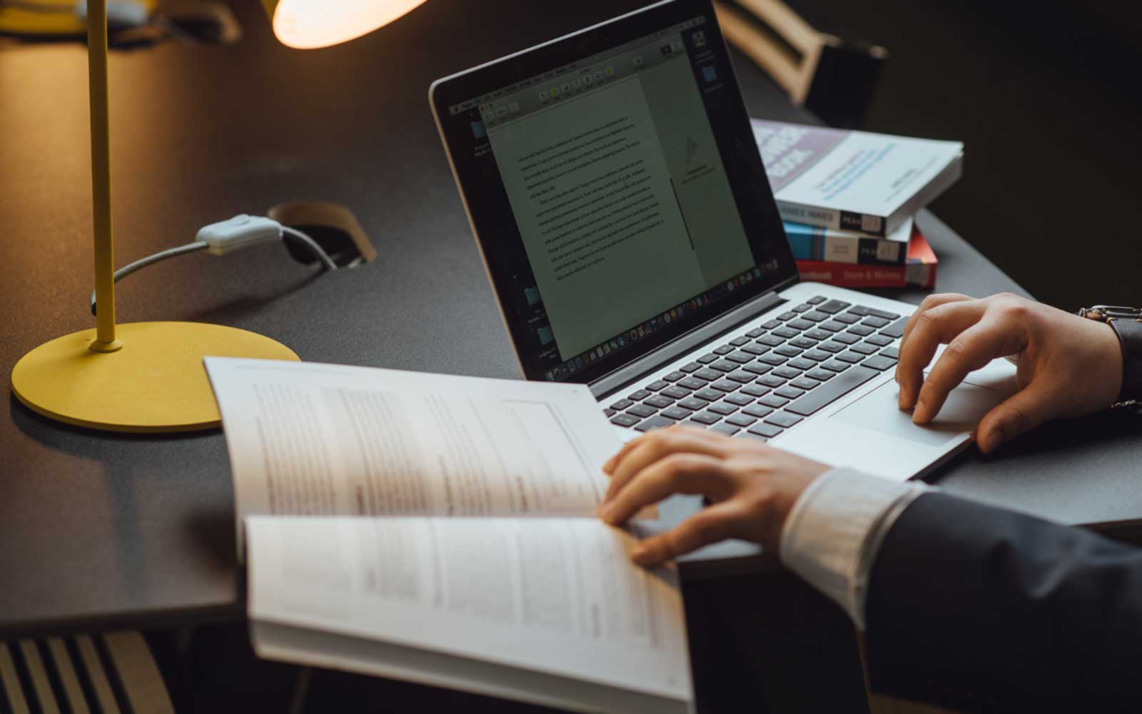 Typing notes from a book onto a laptop