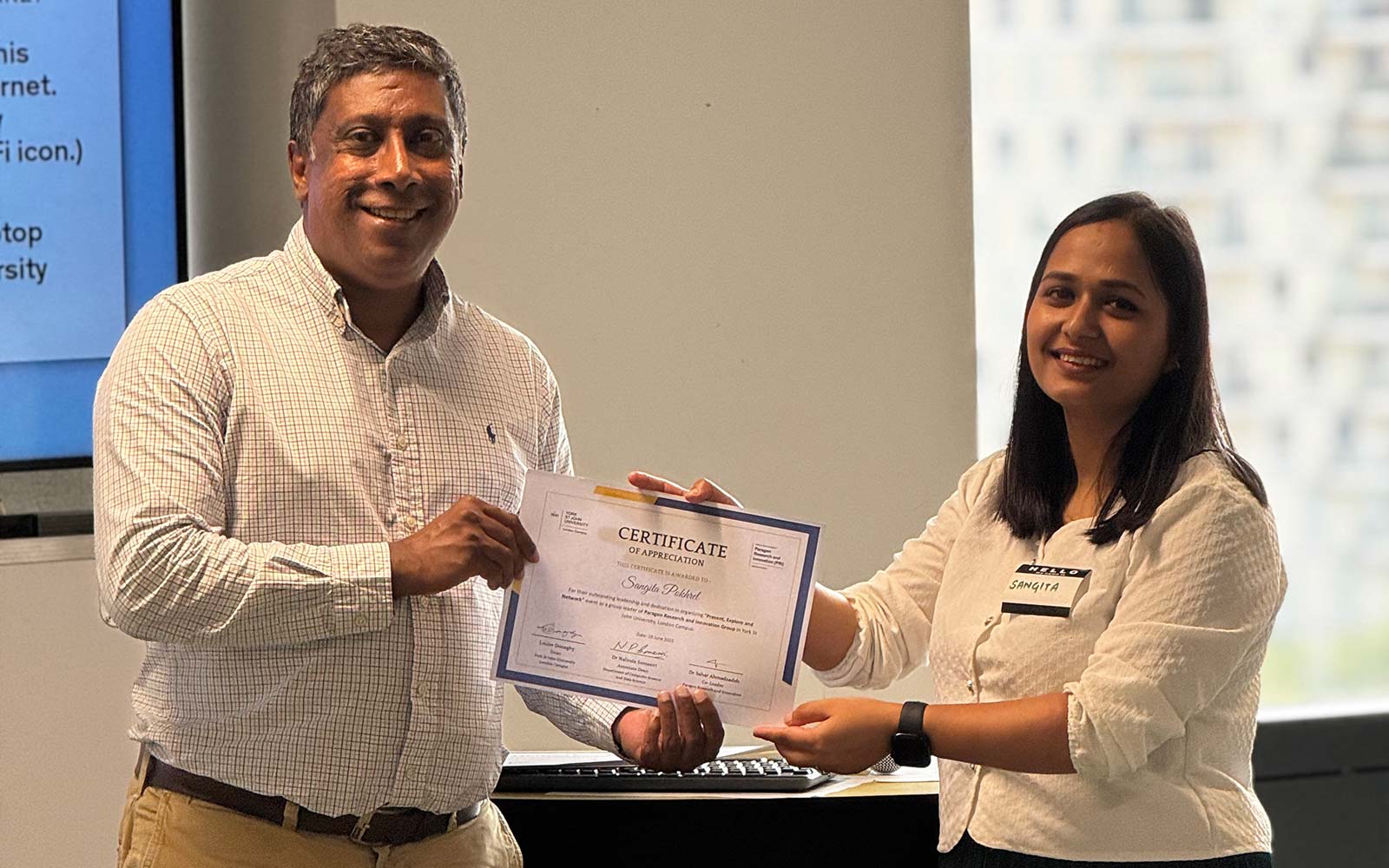 Staff member presenting student with certificate