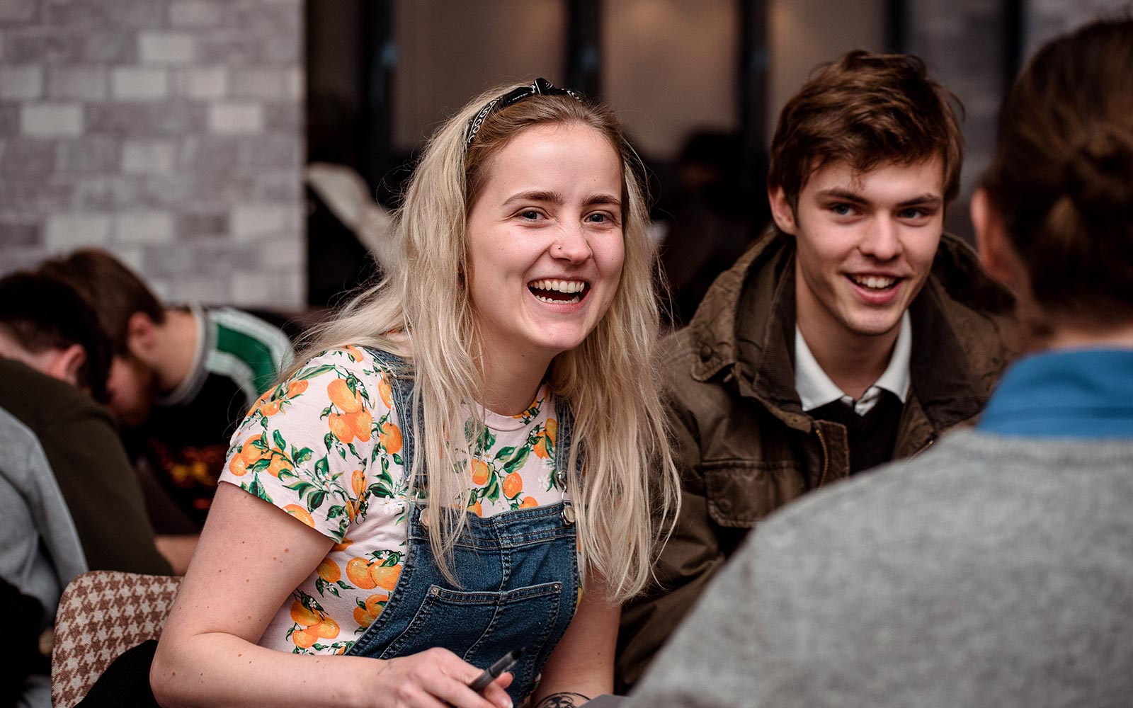 Student smiling and laughing with friends at a social event in Students Union