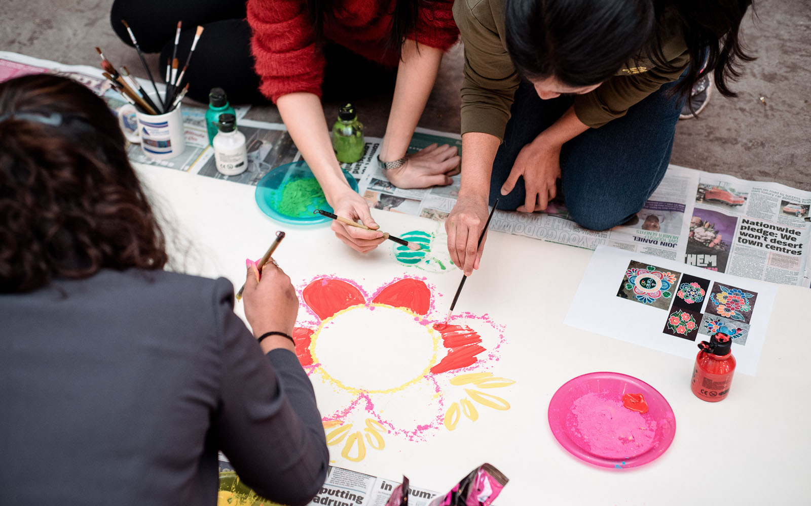 Students working together to paint flower