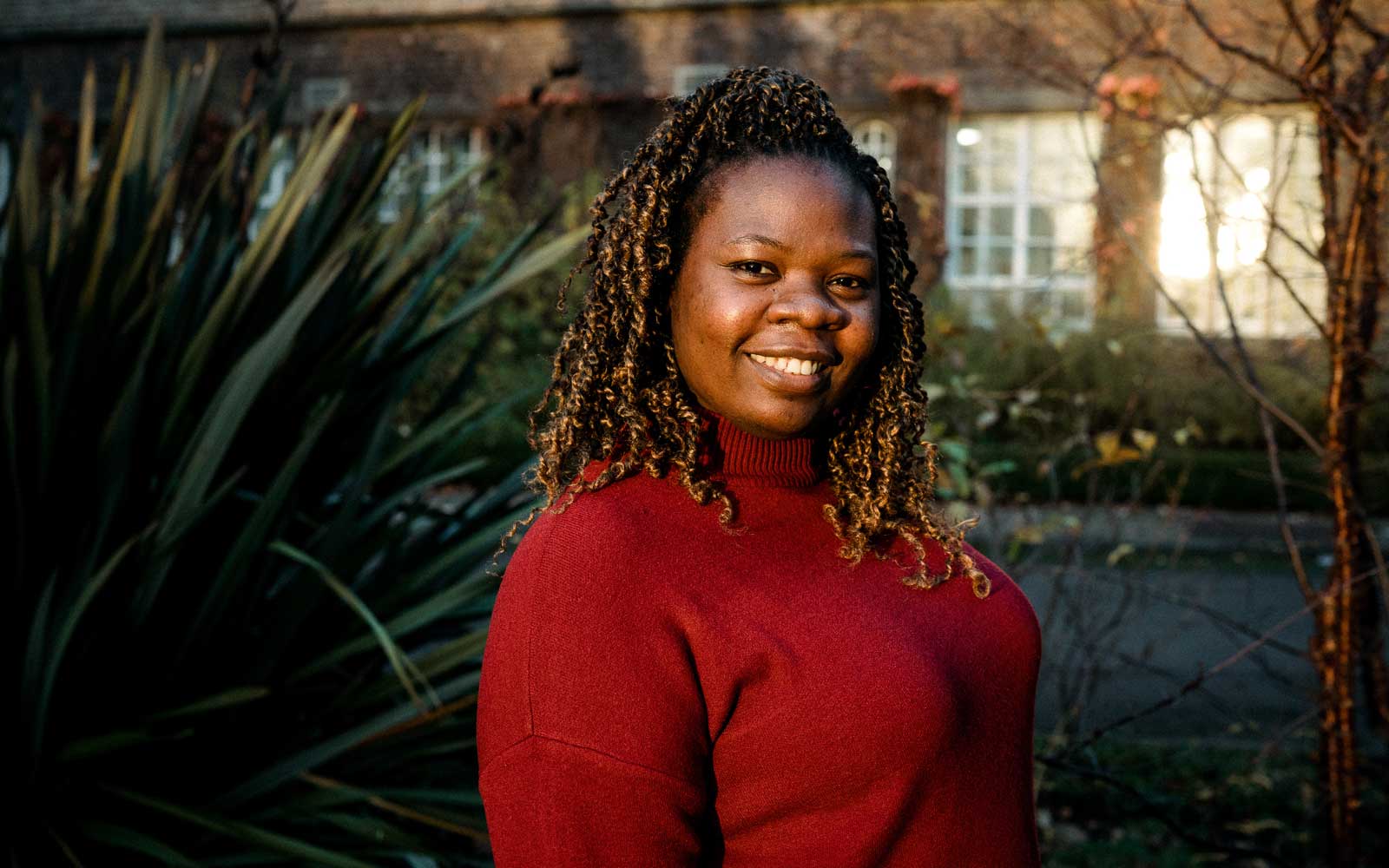 Student outside on campus, smiling at camera