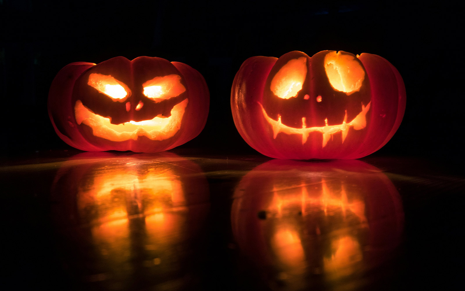 Carved pumpkins lit up in the darkness
