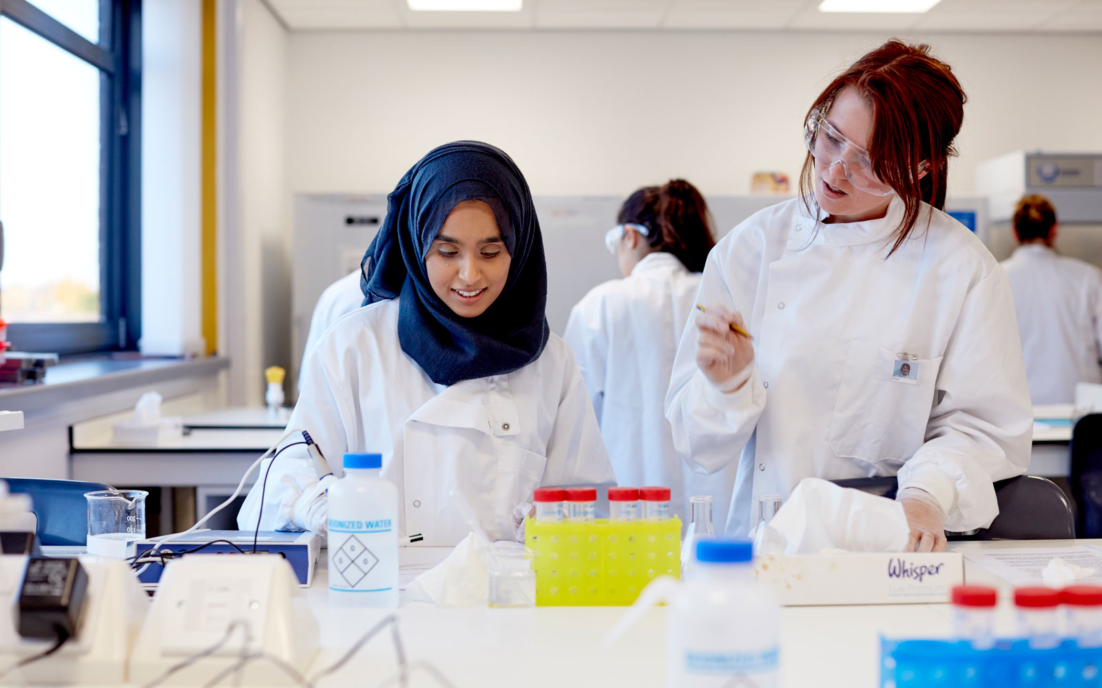 Two health science students working in labs