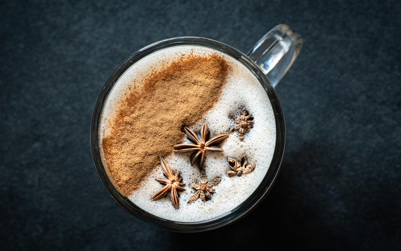 Cup of coffee from above with cinnamon and star anise on top