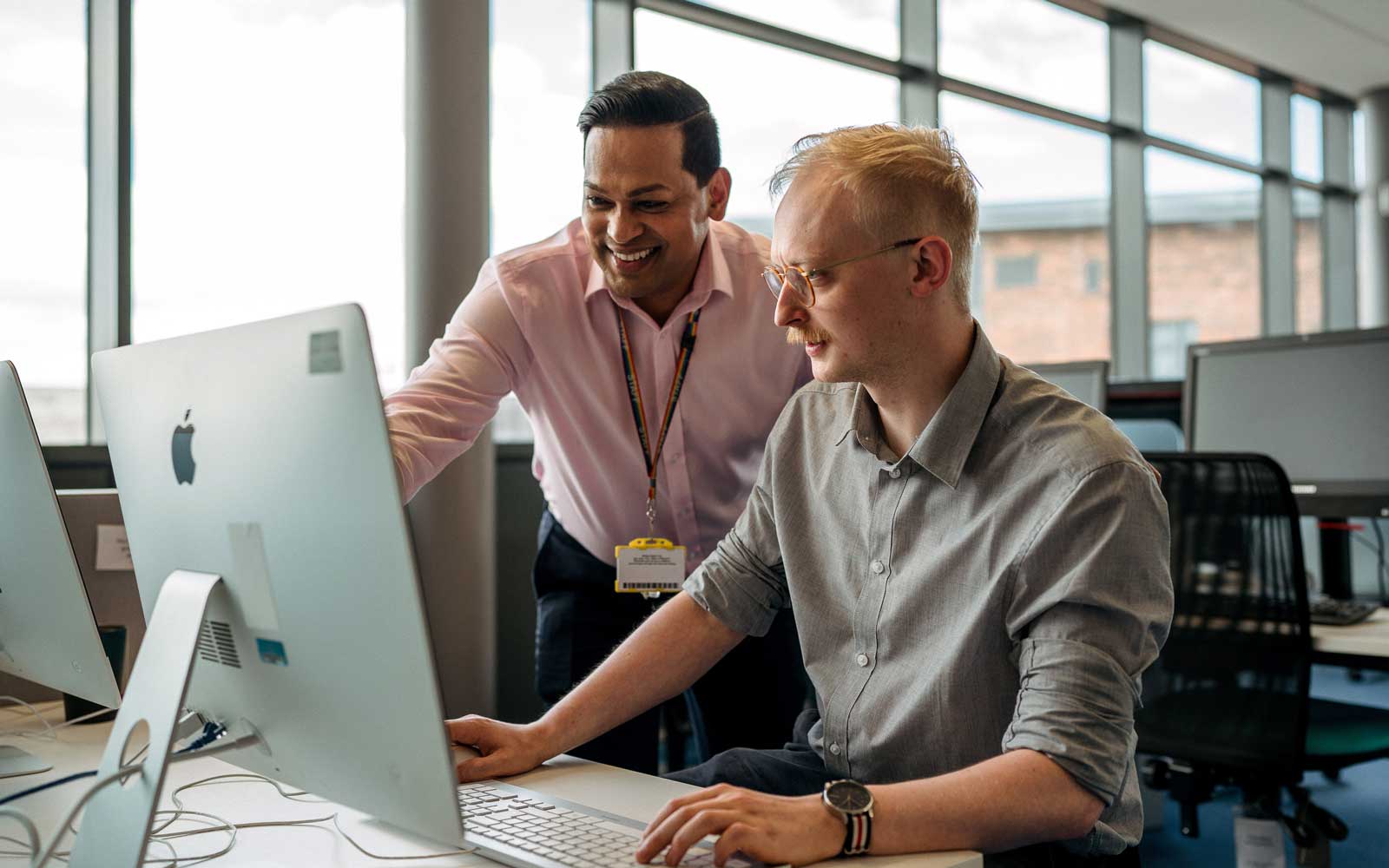 Member of staff providing IT help on Library computer