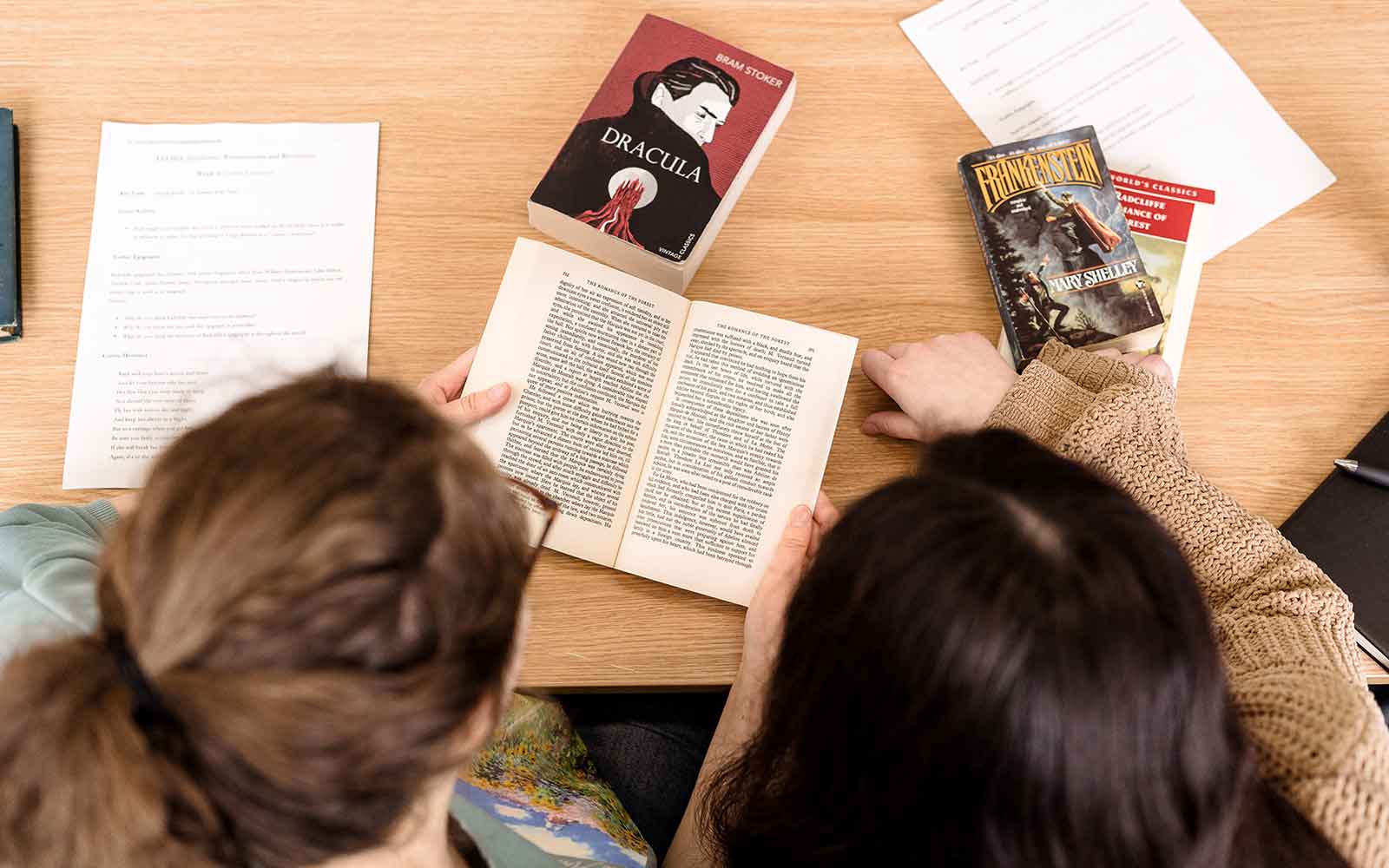 Overhead view of students reading classic books.