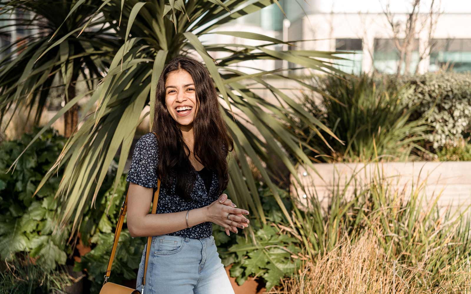 Student outside London Campus, smiling at camera