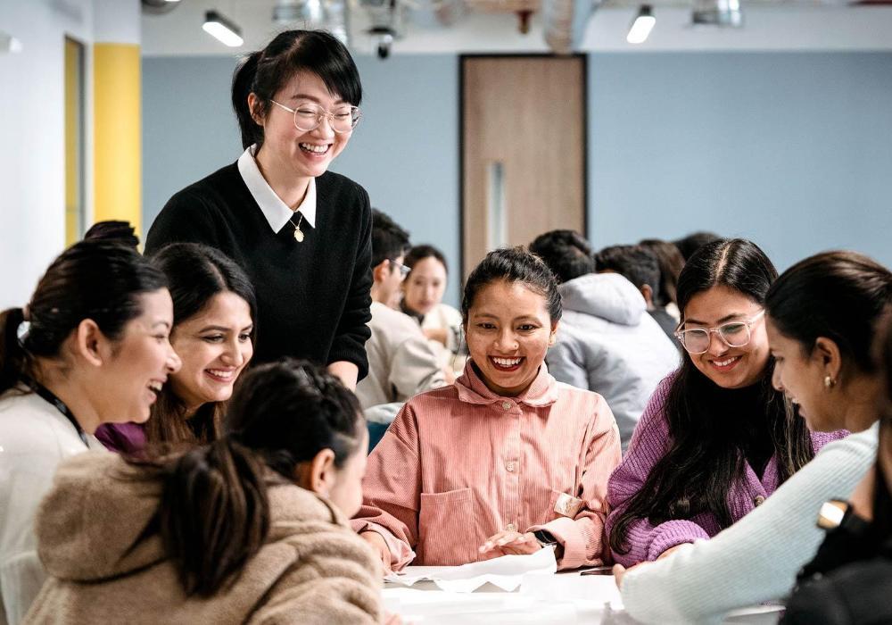 Lecturer laughing with group of students