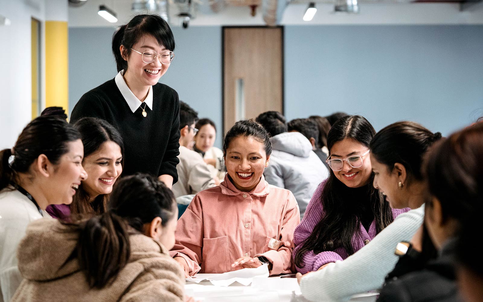 Lecturer laughing with group of students