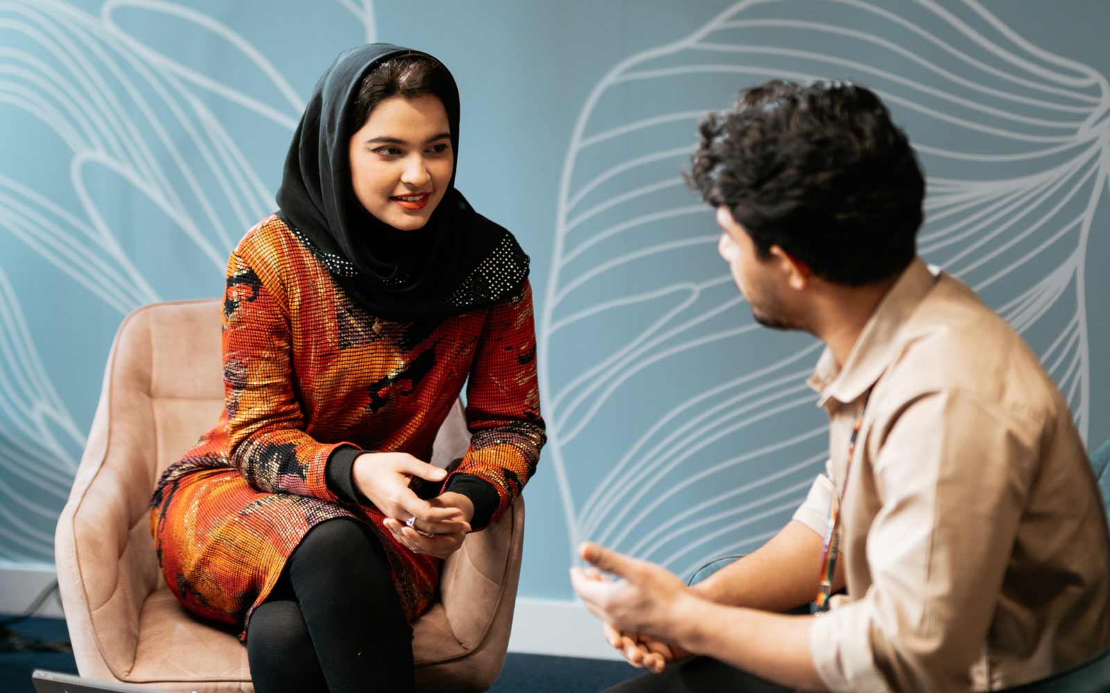 A student and staff member talking together.