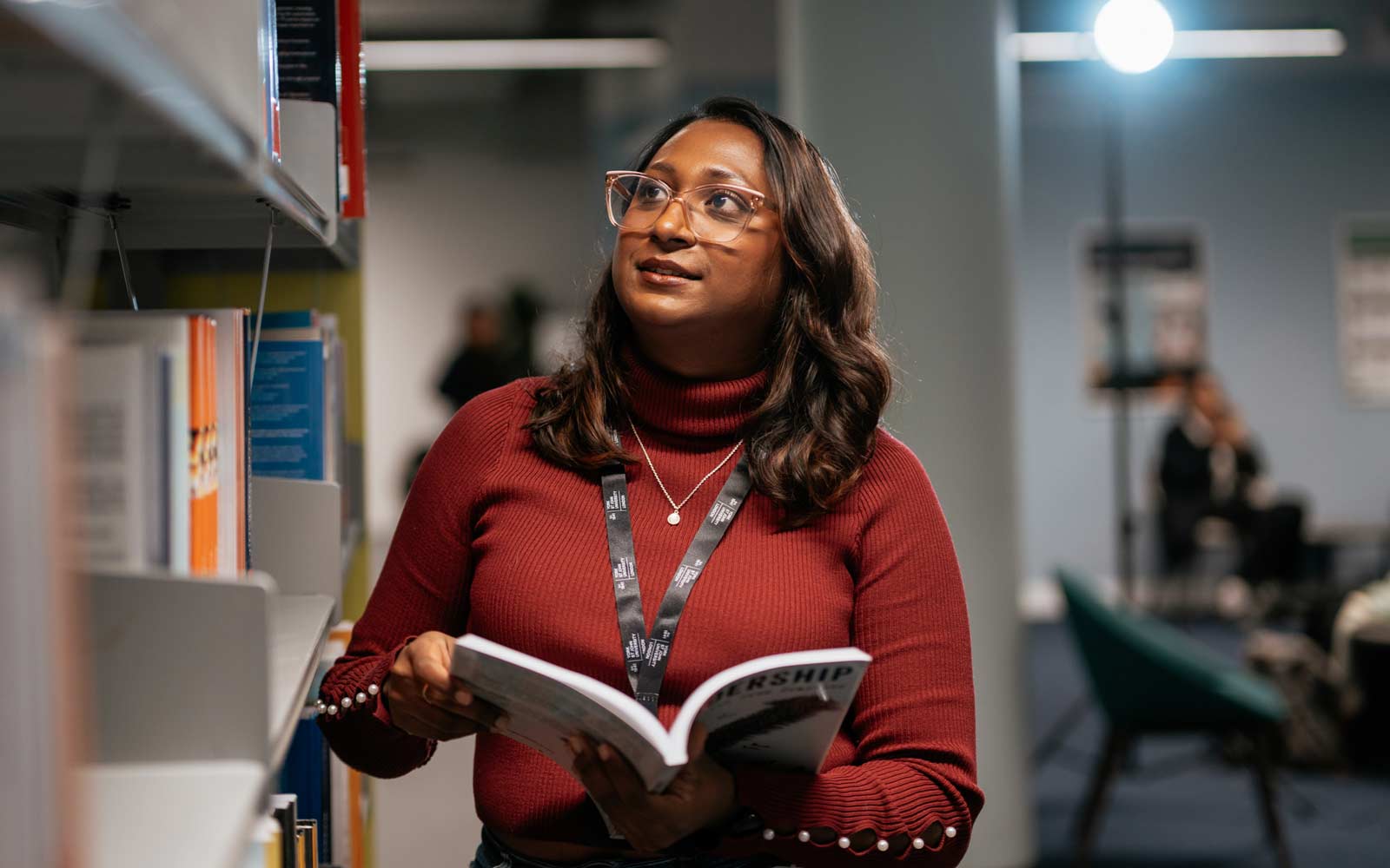A staff member looking through the shelves in our London campus library.