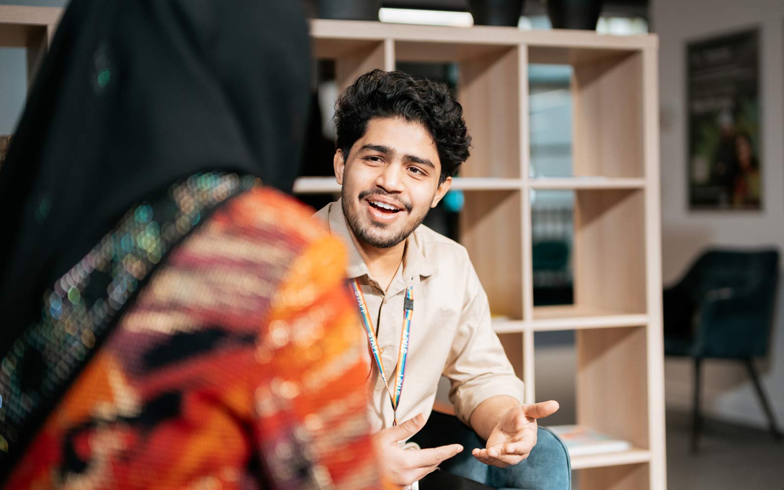 A staff member assisting a student in the London campus student hub.