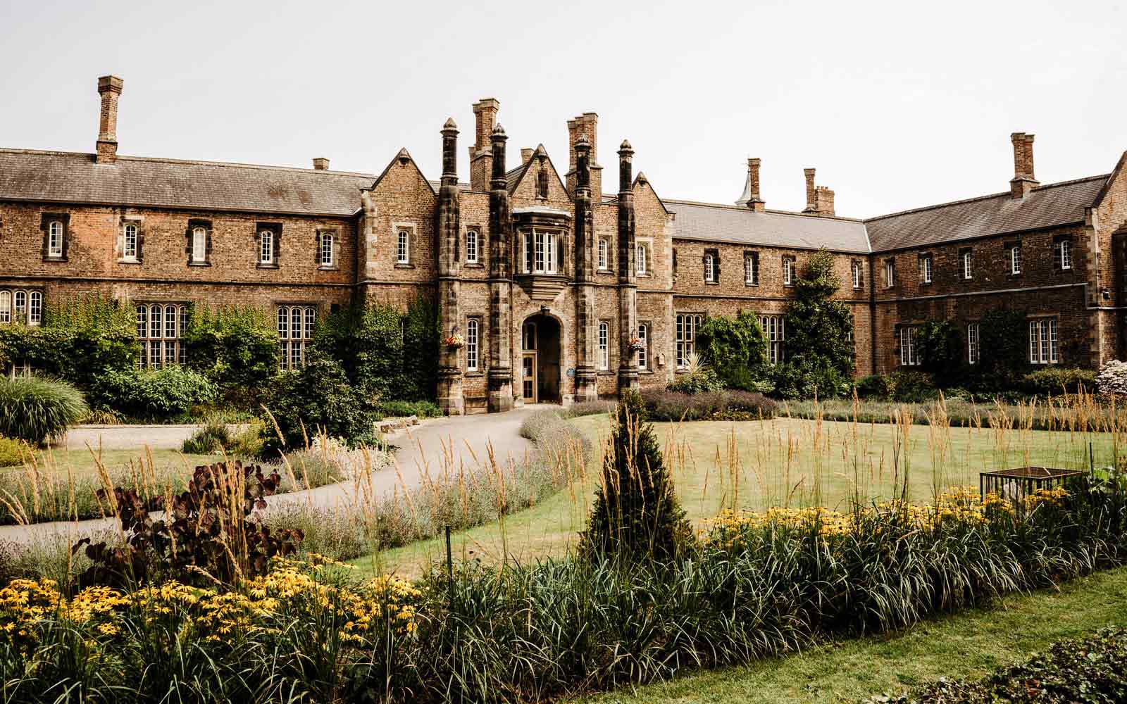 The historic Lord Mayor's Walk building, with a view of plants and foliage in the foreground