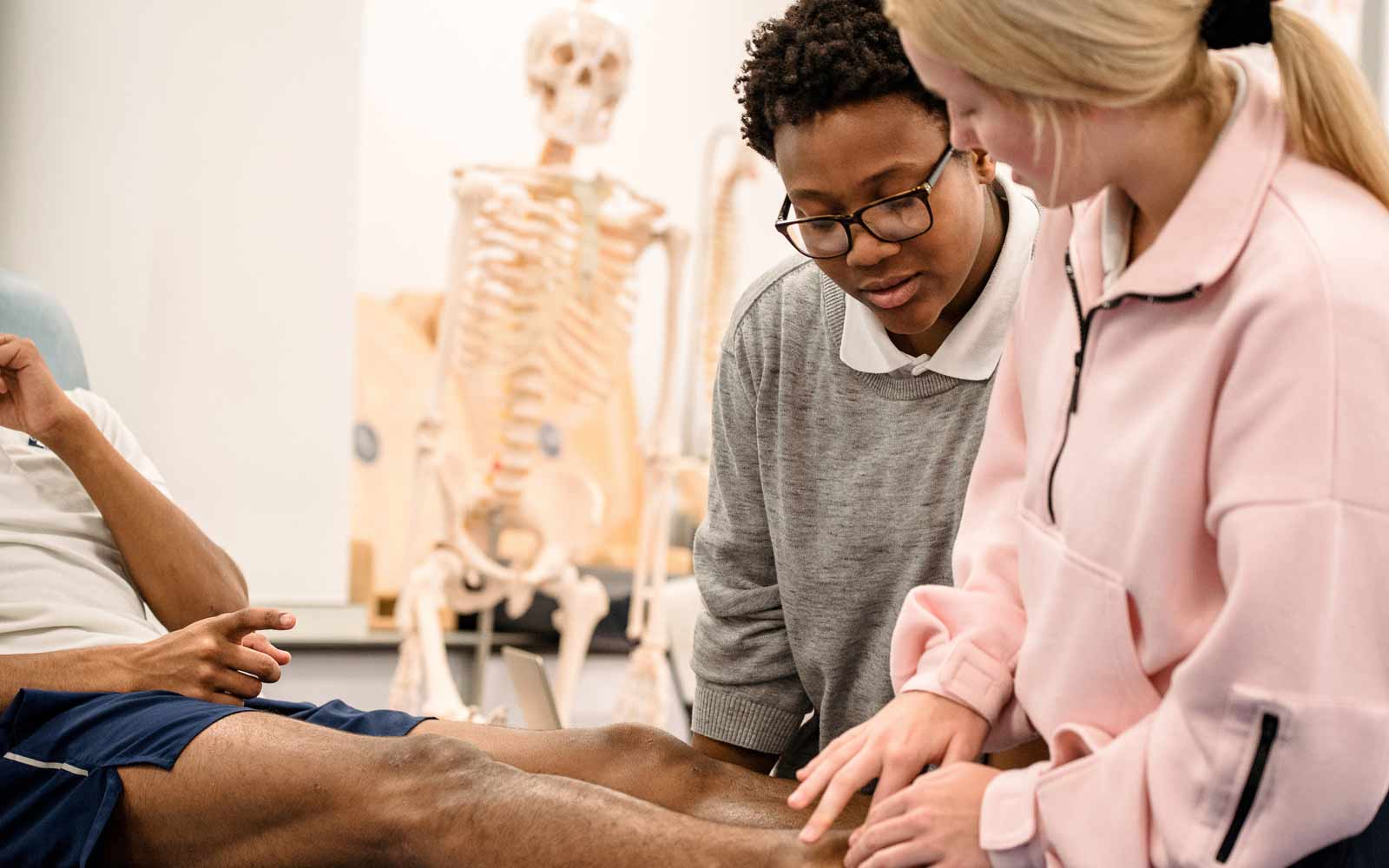two students working with a patient