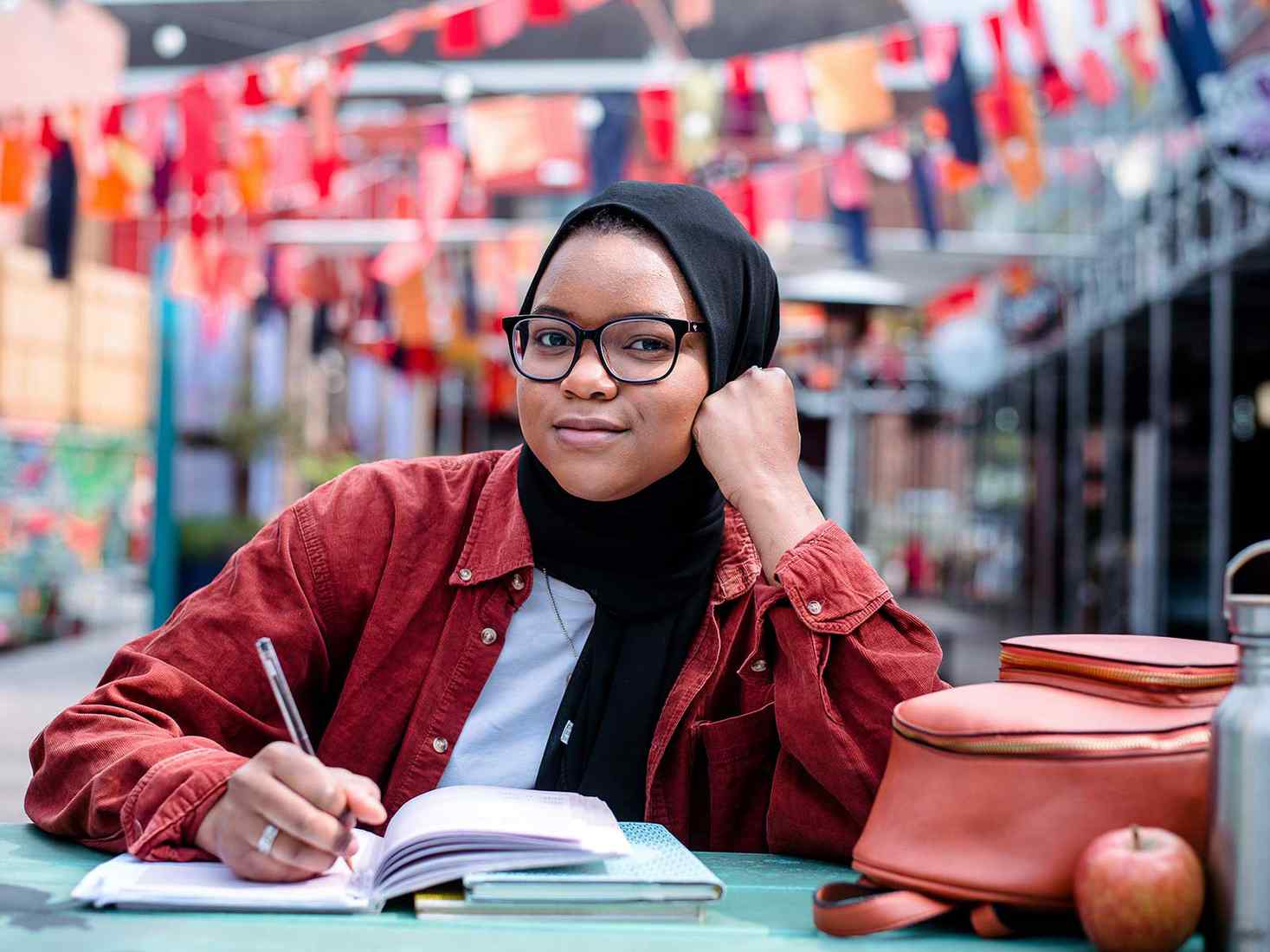 A student sat at a table writing in a notebook