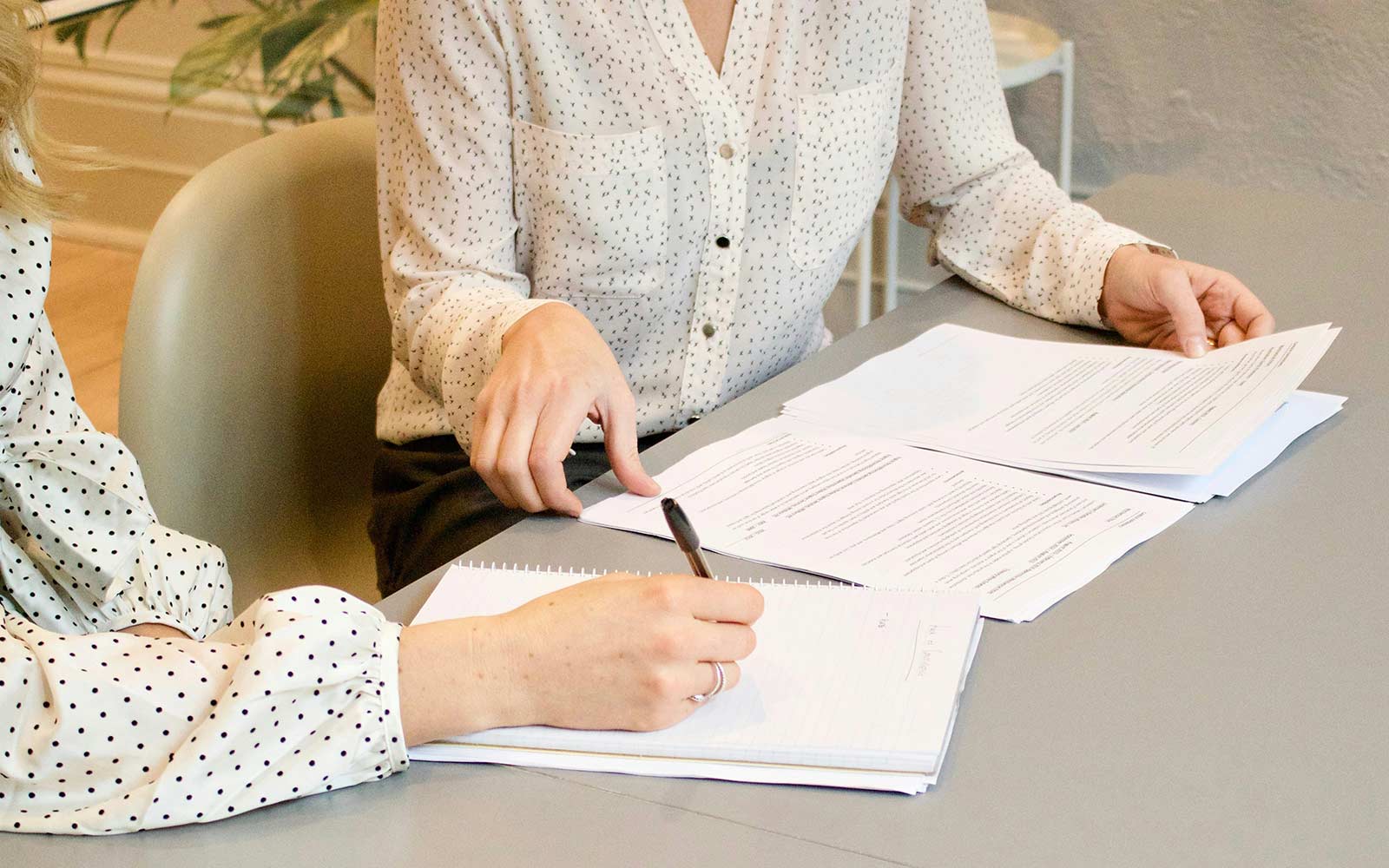 Two work colleagues looking at CVs and making notes