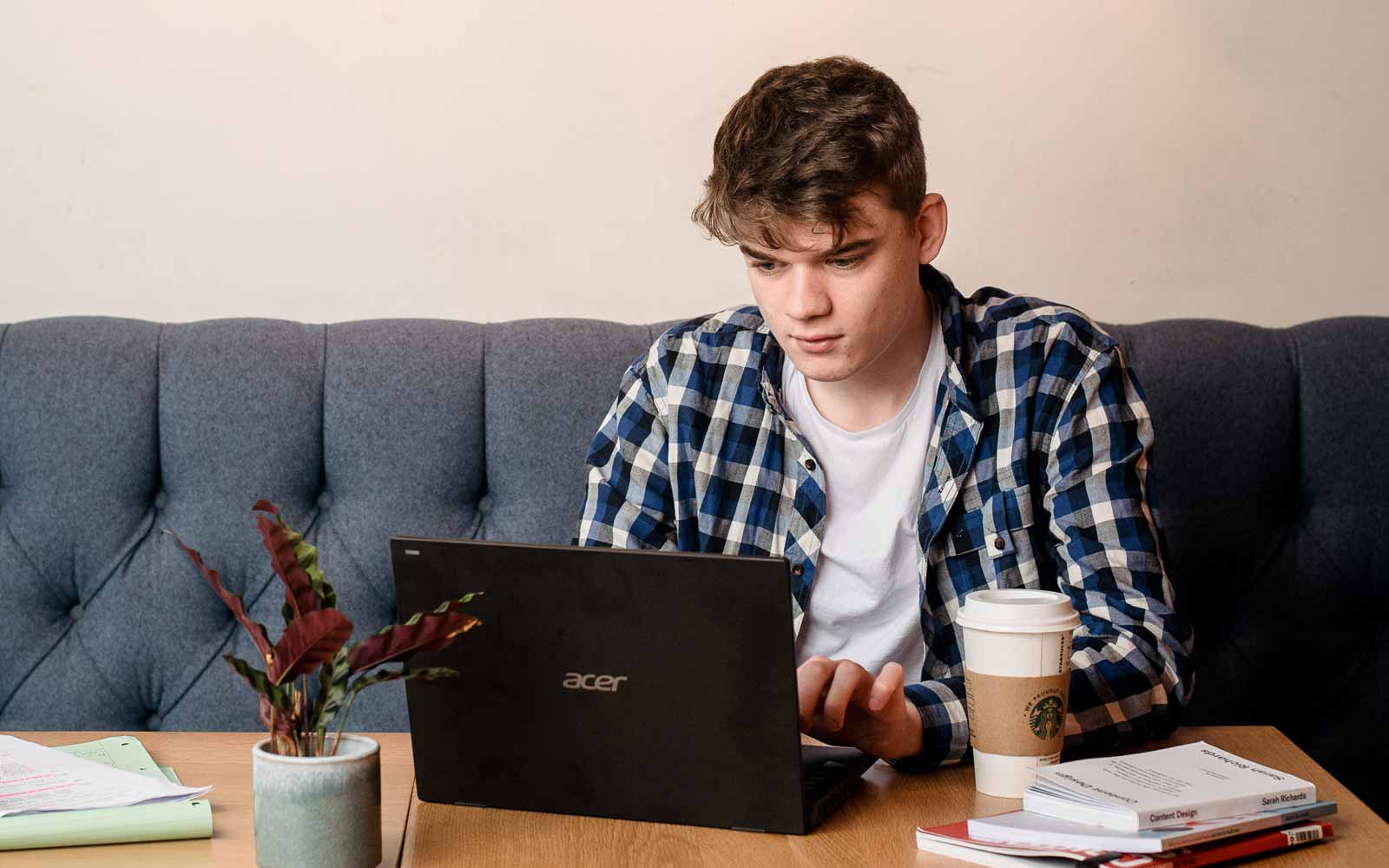 A student sat at a table using a laptop.