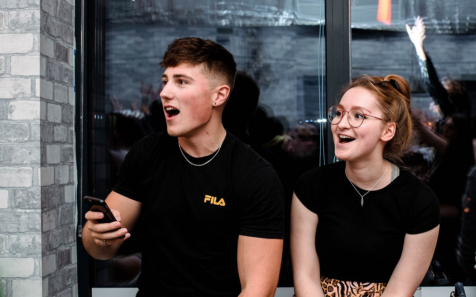 Students in the Students' Union at a social event, looking surprised yet happy