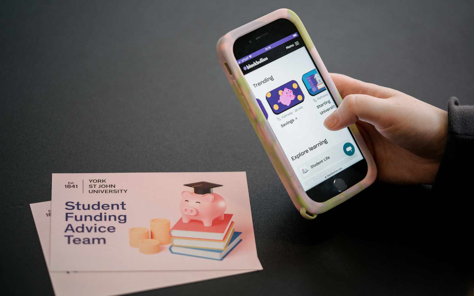 Postcards for Student Funding Advice team, alongside a phone showing the Blackbullion app.