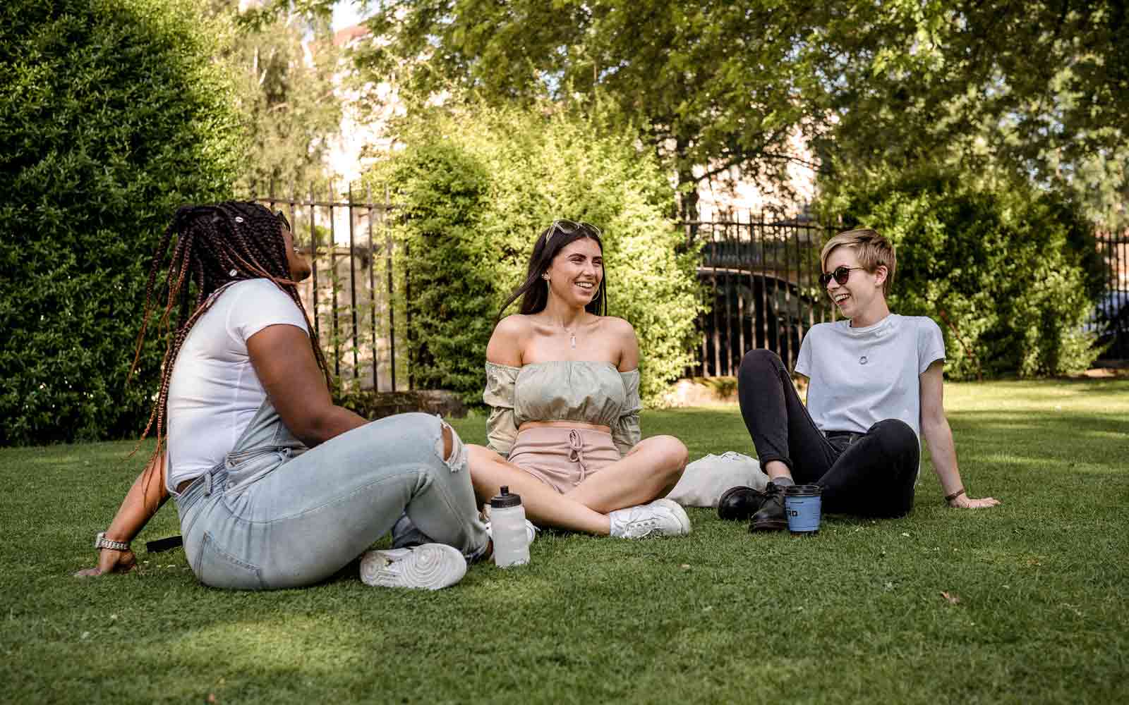 Three students sitting in a park.