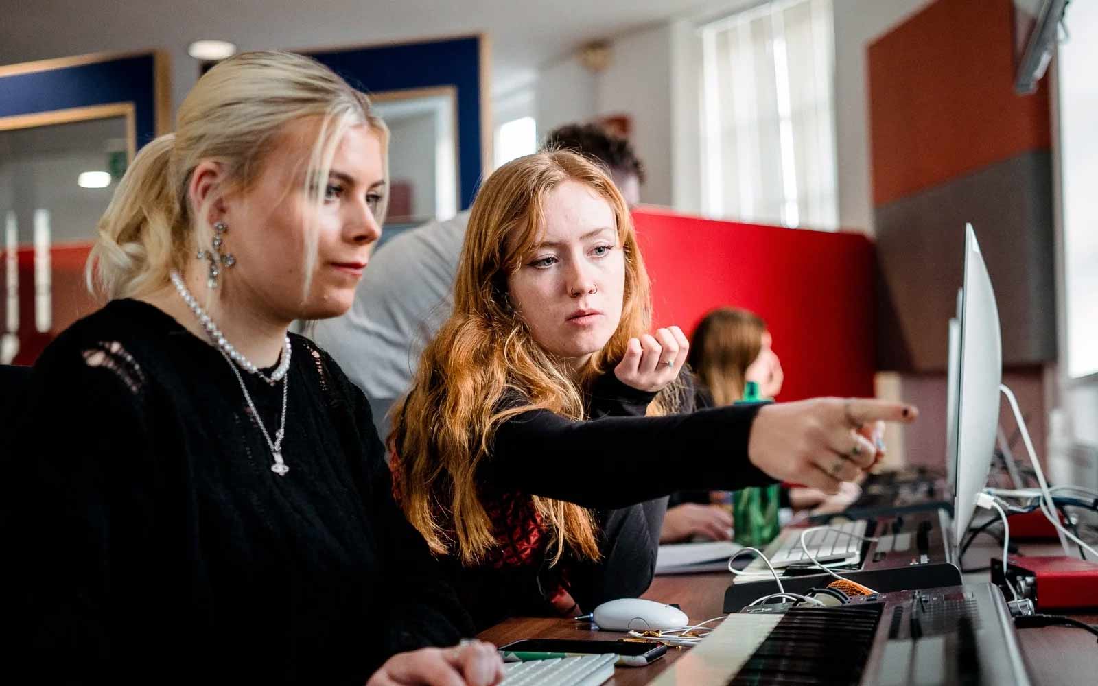 Two students work together at a computer.