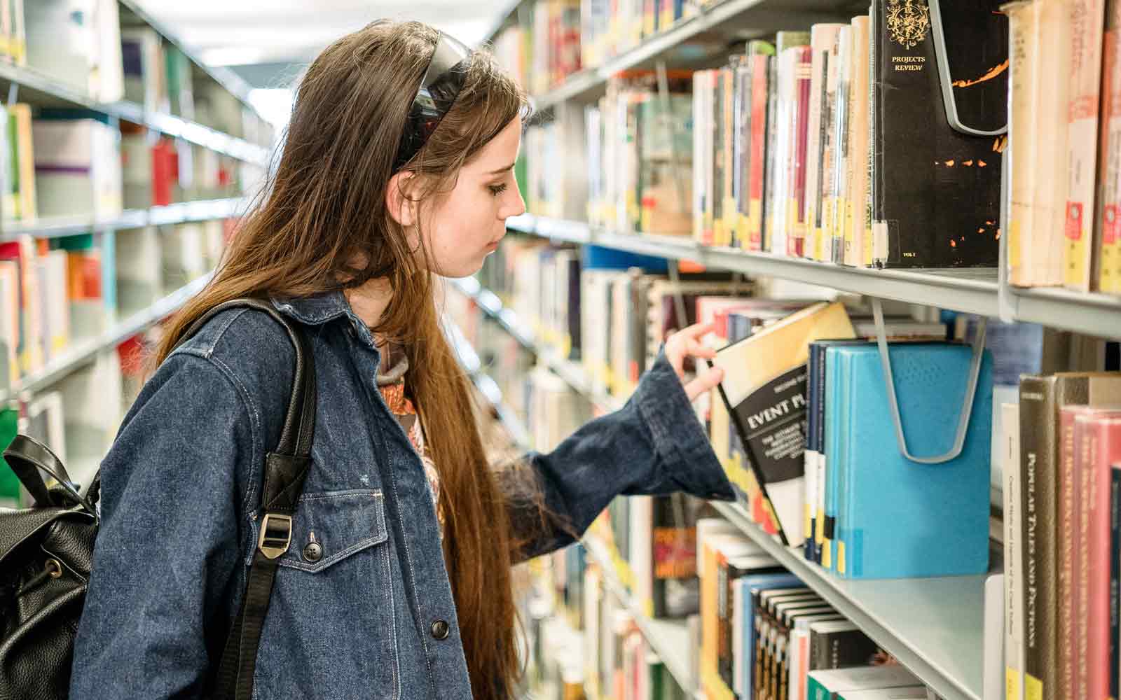 A student looking through the shelves in the library.