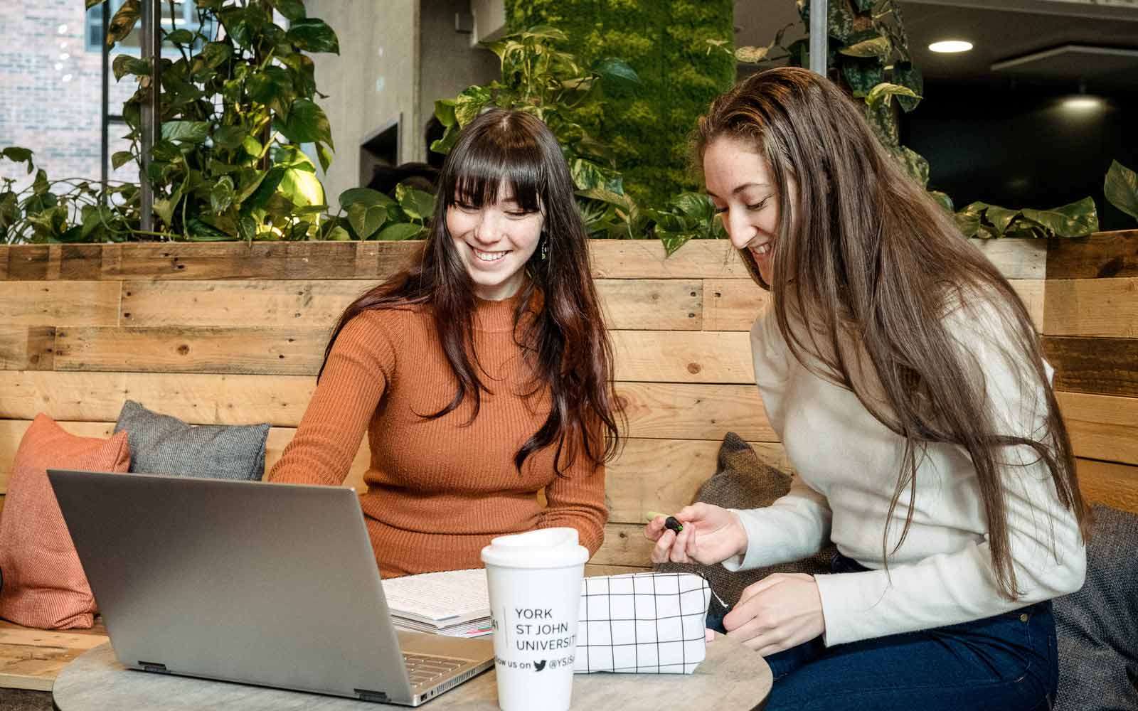 Two students reading from a laptop.