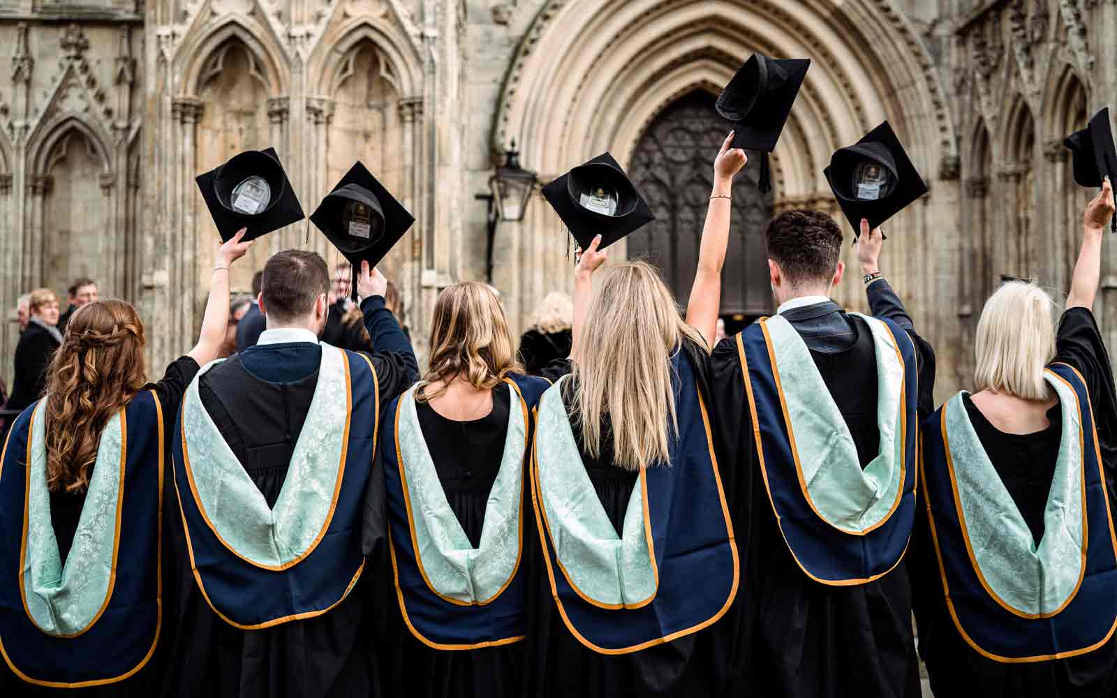 Students throwing mortarboards at graduation