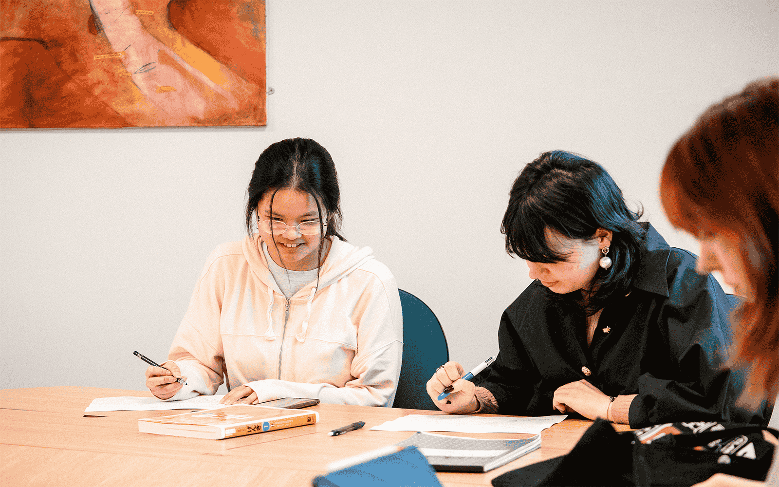 Three students studying around a table