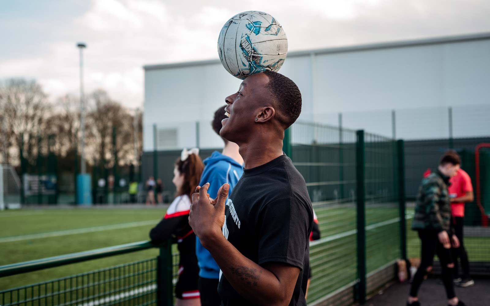 A student balancing a football on their head.